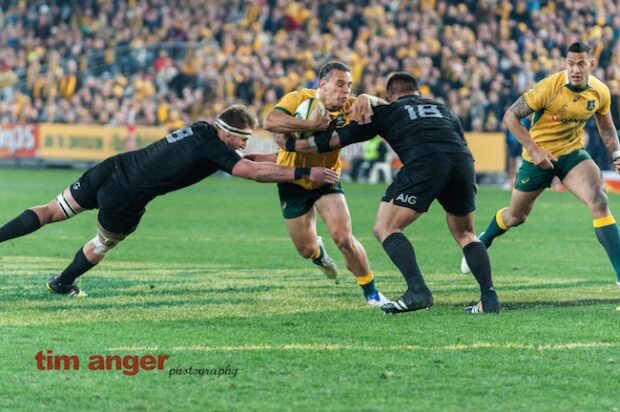 Matt Toomua, who replaced the injured Matt Giteau, attempts to sidestep All Blacks' Kieran Read and Nepo Laulala.